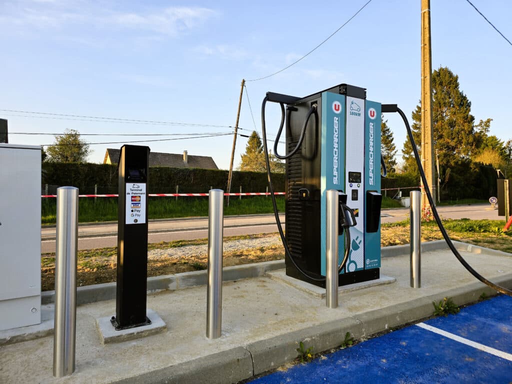 Borne de recharge 180kw avec terminal de paiement sur un parking de Super U